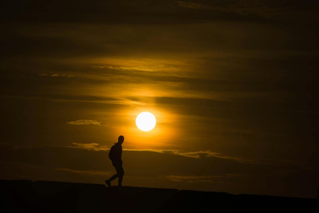 Seguir Adelante: La Actitud que Define Tu Camino man walking sunset